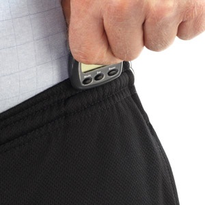 Male hand attaching a pedometer to his sweat pants in order to count the steps he will take on his daily walk.
