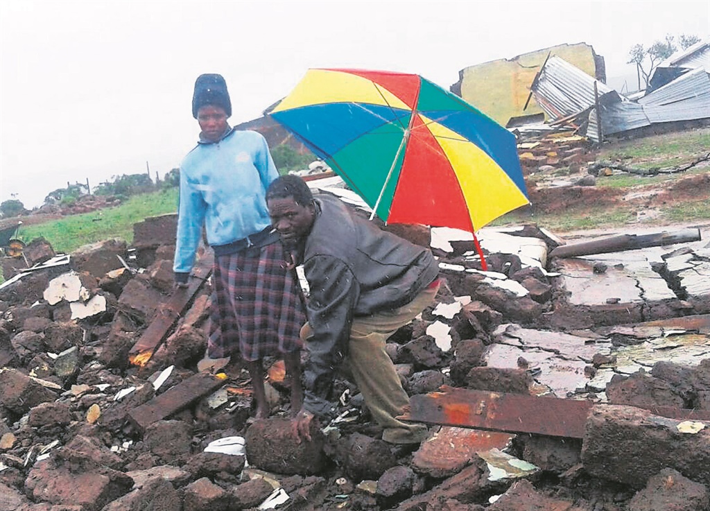 Cikizwa Mpetsheni and her uncle Zwelakhe Diniwe stand in the ruins of the house that collapsed on gogo Anna Sokoyi during a violent storm in Mount Frere.            Photo by Nomzamo Yuku 