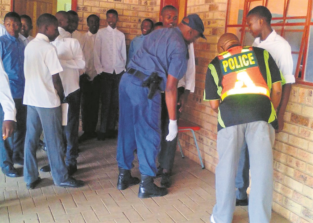 Cops search pupils for drugs and weapons during a raid in Weilers Farm.                Photo by Sonqoba Kunene  