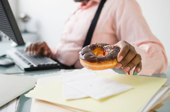 A working man snacks on a donut.