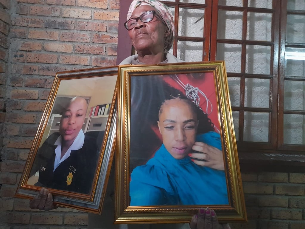 Samaria Mazibuko holding pictures of her slain daughters.