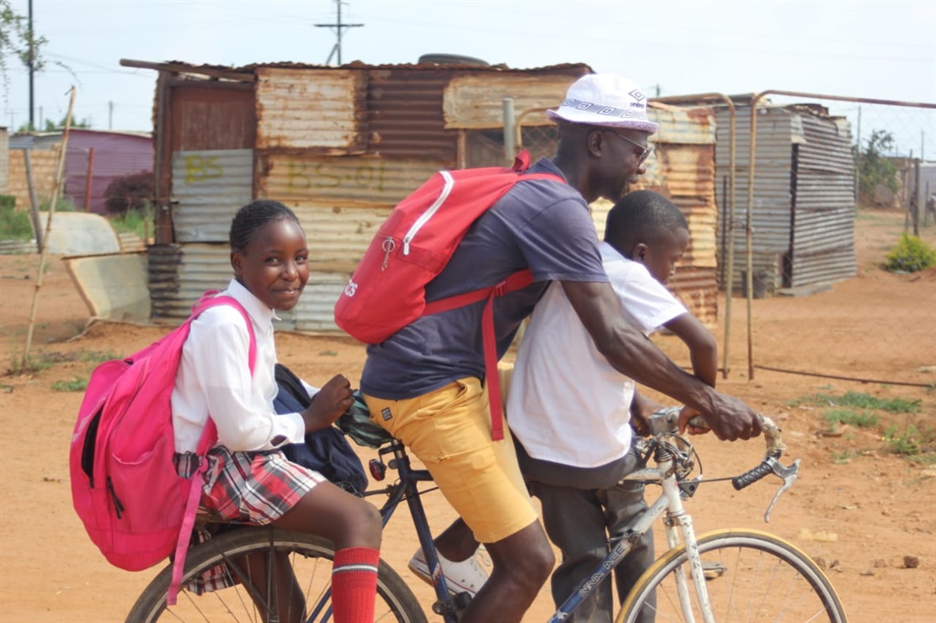 Drengo Matlou transports schoolkids on a bicycle. Photo by Thabo Monama