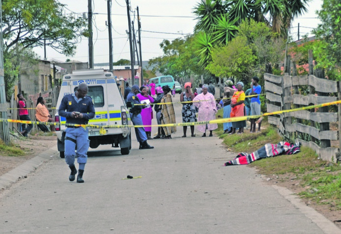 Cops and residents at the scene where the body of Ntuthuzelo Maneli was found.             Photo by Luvuyo Mehlwana