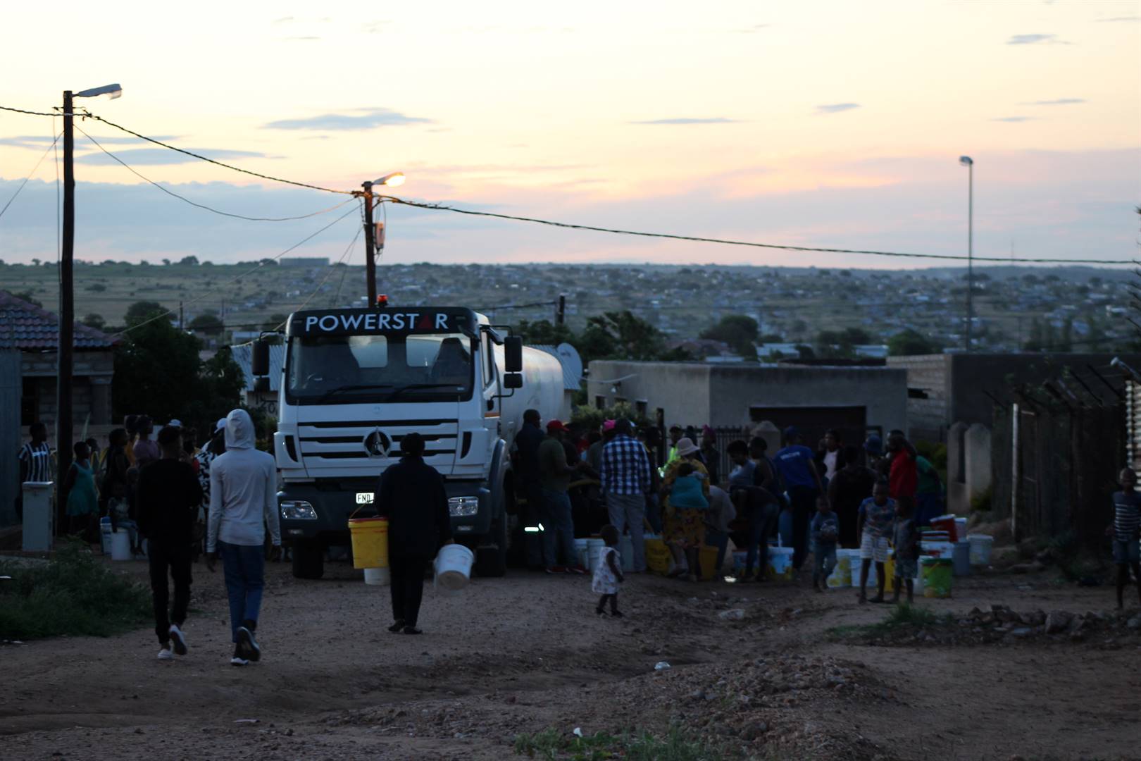 Residents of Extension 71B gather around a water tanker to get water. Photos by Judas SekwelaPhoto by 