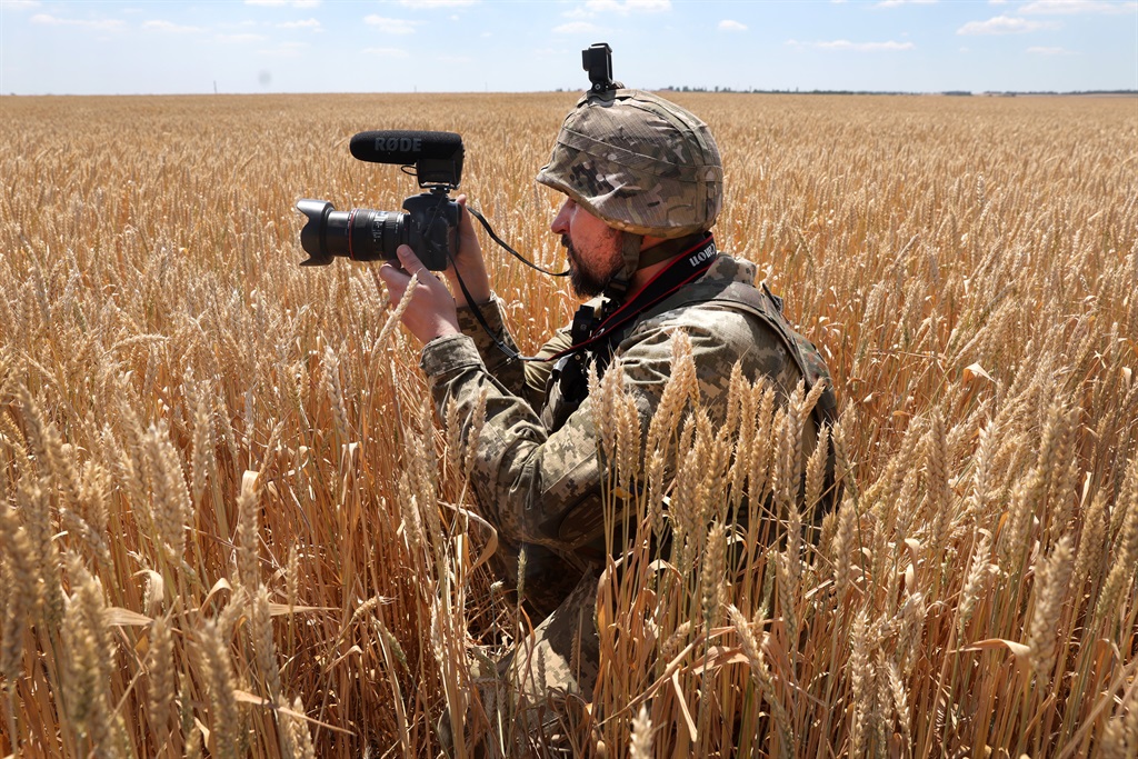 A Ukrainian military journalist takes cover in a wheat field as he captures video while a tank team with the 14th Mechanized Brigade of Prince Roman the Great fire on an enemy position on 1 July in the Donetsk District, Ukraine.