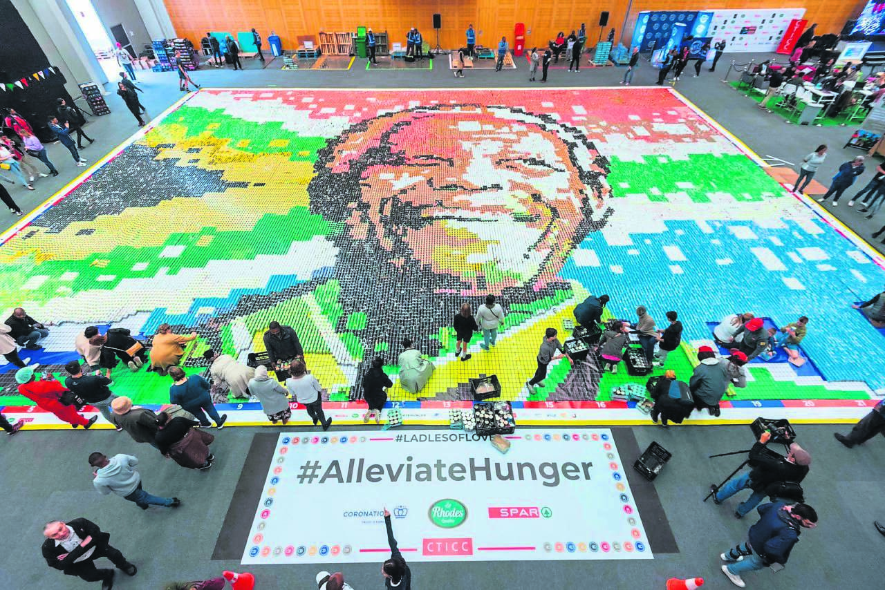 Hundreds of volunteers joined food relief NGO Ladles of Love to build the world’s largest food can mosaic of Madiba’s face at the CTICC on Monday 18 July.PHOTO: Werner Ryke