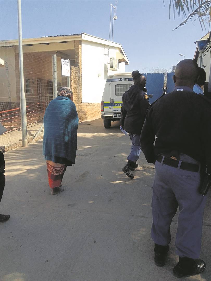 The gogo is escorted from the Mkhuhlu Magistrates Court after being granted bail. Photo by Oris Mnisi 