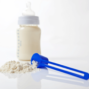 Bottle with a scoop of formula milk