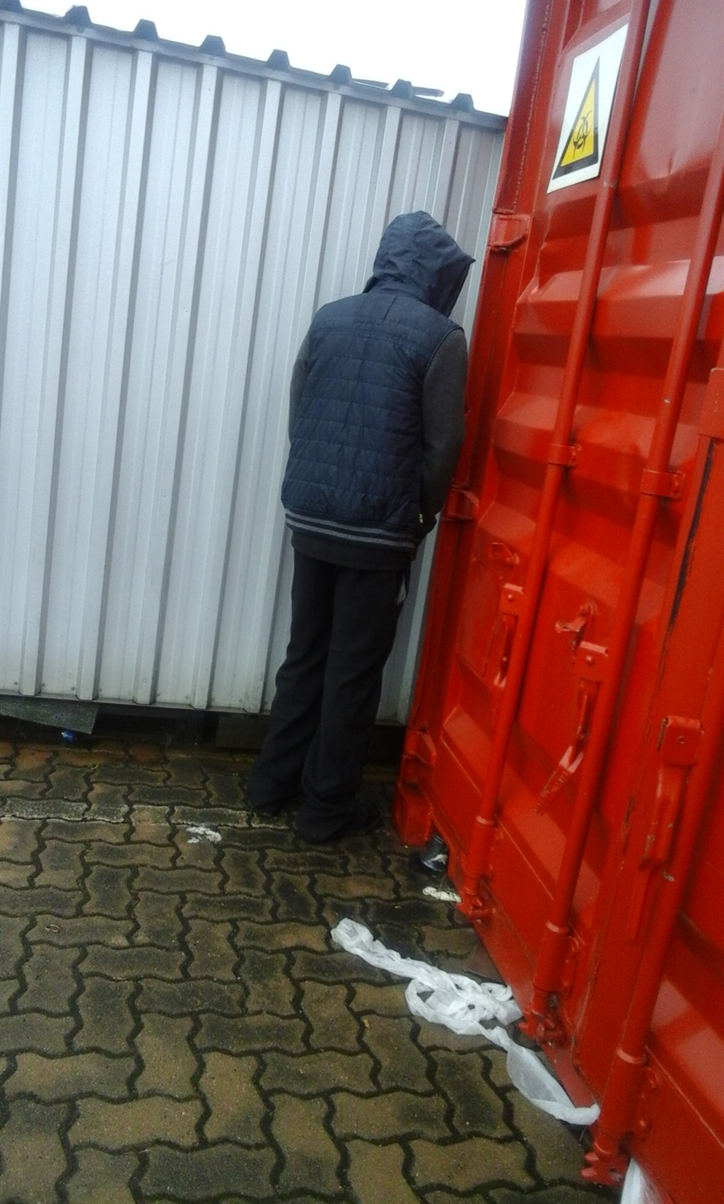 Taxi driver peeing behind containers at his taxi rank in Durban.  Photo by Mxolisi Mngadi 