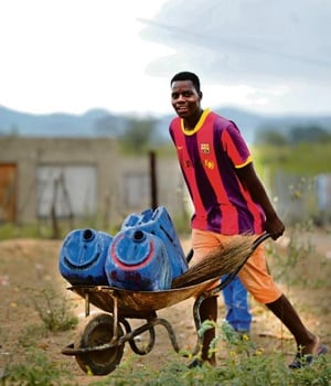 Cardo Rikhotso of Siyandhani Village near Giyani, transports his water by wheelbarrow. Residents buy water from people with boreholes or from the water merchant in town, thanks to a project that appears to have flopped

PHOTO: LUCKY NXUMALO