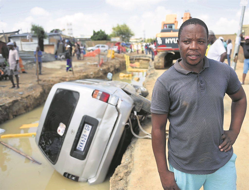 Chris Lekokotla blames the Joburg Road Agency after his car landed in water in Tembisa.                                                Photo by Lucky Maibi 