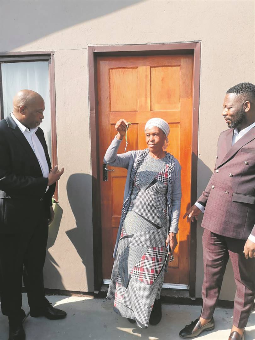 Gogo Veronica Nkosi receives the keys to her house from MEC Speedy Mashilo (left) while Mayor Mhlonishwa Masilela looks on.   Photo by Bongani Mthimunye