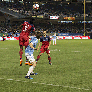 Player controls header ball during a soccer match. 