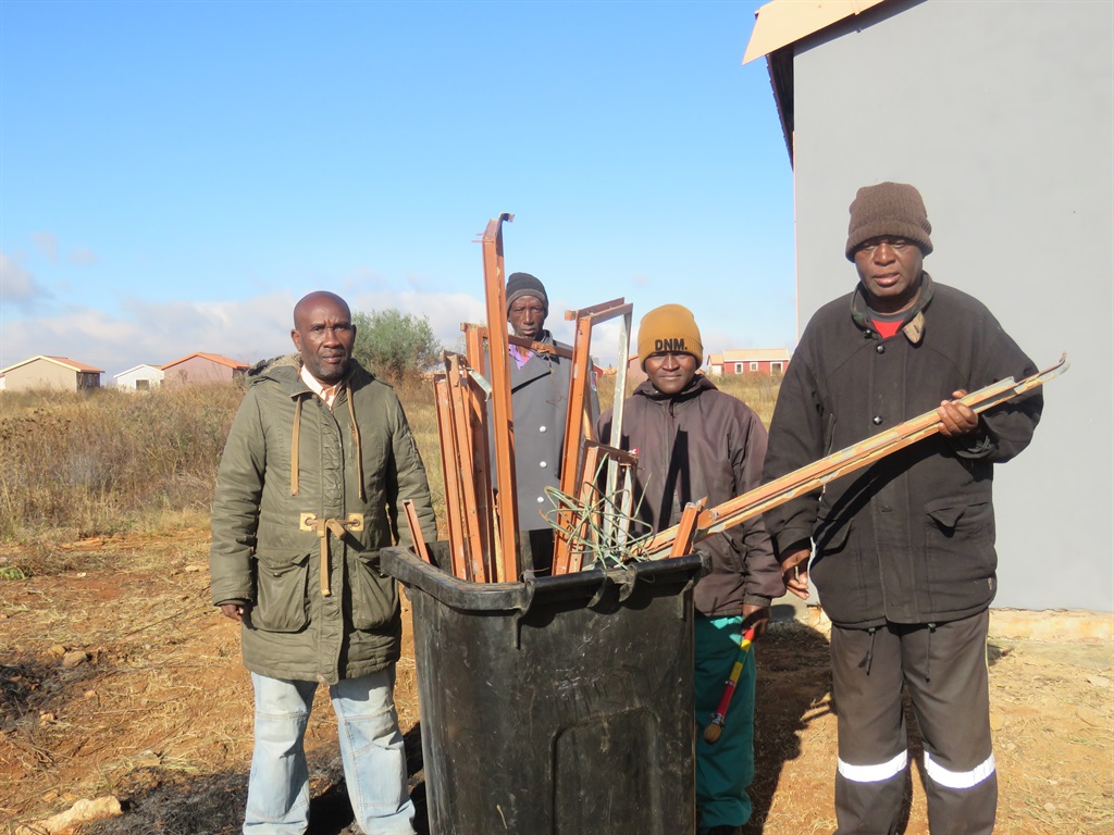 Patrollers with some of the damaged window frames recovered from thieves. Photo by Ntebatse Masipa