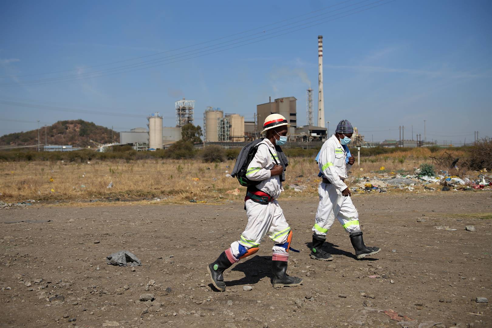 Two mine workers at Sibanye-Stillwater's Marikana operations walk home after their day shift. Photo: Tebogo Letsie