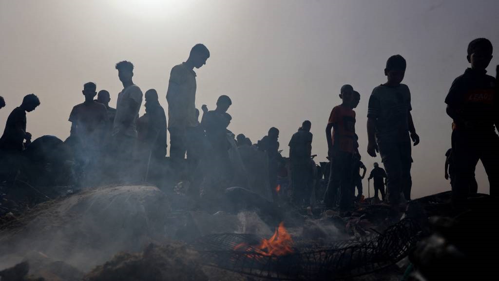 Palestinians gather at the site of an Israeli stri