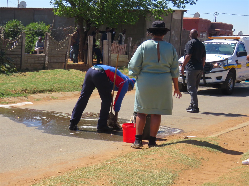 The Masilela family cleaning the scene. Photo by Ntebatse Masipa