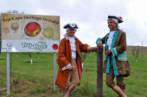 Two Tru-Cape staffers dressed in colonial attire and smiling next to a Tru-Cape billboard. Picture: tru-cape.com