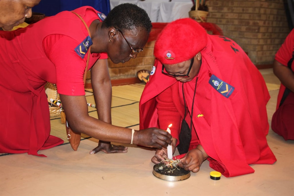 Gogo Muntu Segage and another sangoma light a candle before giving out certificates to izangoma. Photo by Phineas Khoza