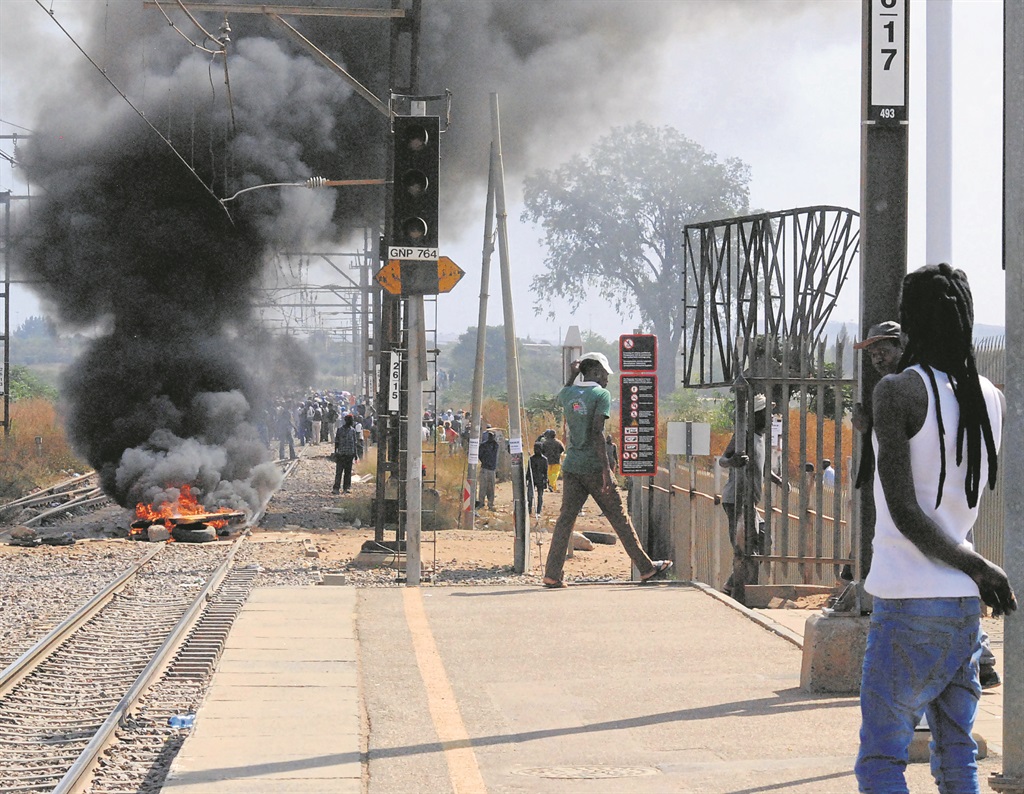 Residents of Mamelodi who occupied an open piece of land blocked the railway line with burning tyres.                               Photo by Karabo Rammutla 
