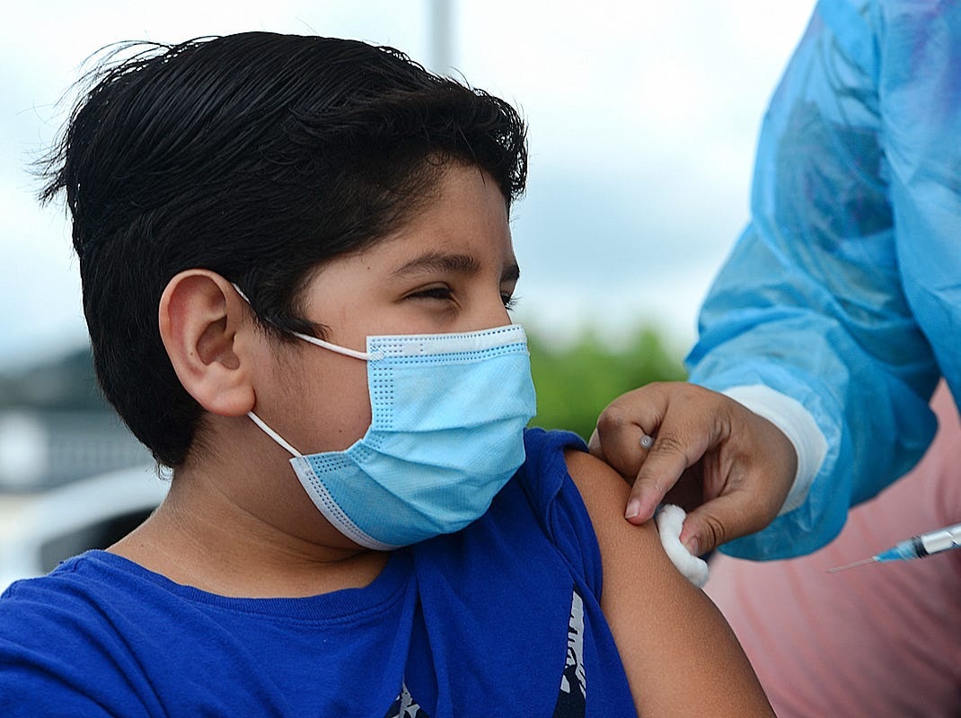 A boy receives the first dose of a Pfizer/BioNTech C0vid-19 vaccine.