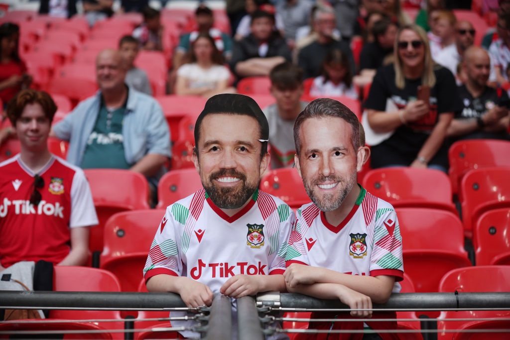 Wrexham fans with novelty masks showing Wrexham owners Rob McElhenney and Ryan Reynolds. (Eddie Keogh/The FA/The FA via Getty Images)