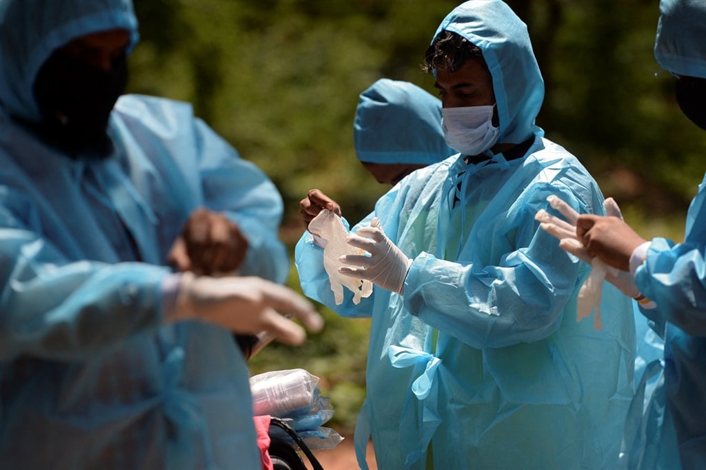 Volunteers wear protective gear as they prepare themselves to bury a body of a Covid-19 coronavirus victim at a graveyard in Chennai, India on 5 June 2021.