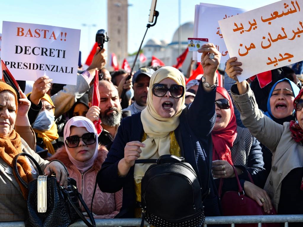 Tunisian demonstrators raise placards as they prot