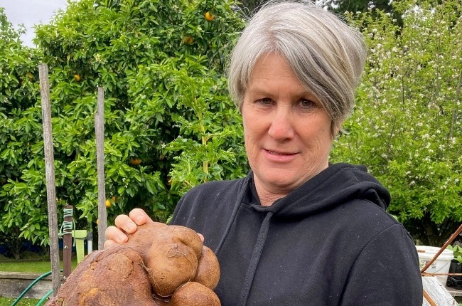 Donna Craig-Brown with the huge gourd that she and her husband found in their garden. (PHOTO: Facebook)