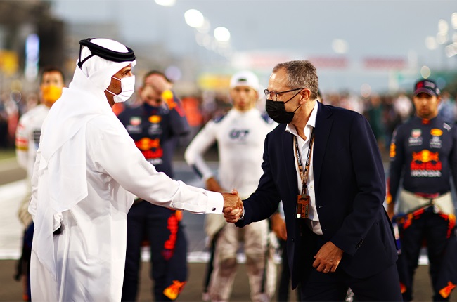 Stefano Domenicali (right), CEO of the Formula One Group, shakes hands with Qatar Prime Minister Khalid bin Khalifa bin Abdulaziz Al Thani on the grid before the F1 Grand Prix of Qatar at Losail International Circuit on 21 November 2021.