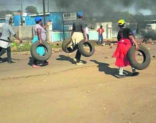 Residents of Jozini carry tyres that were later used to block roads into and out of the kasi as protesters demanded that the mayor step down for failing to solve the area’s water crisis. 