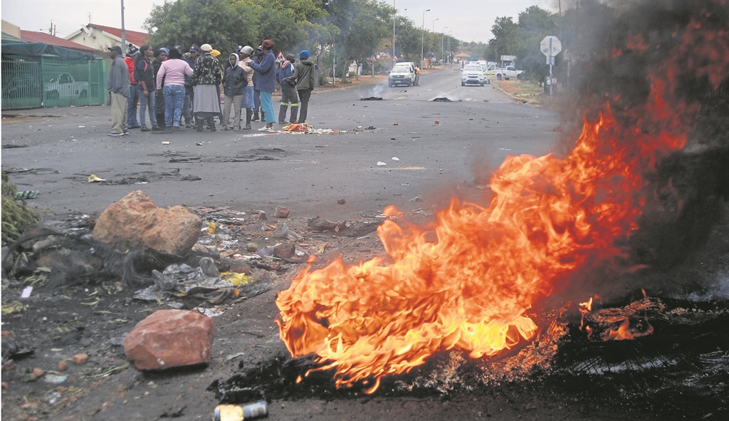 Flaming tyres block the gate leading to the Soshanguve municipal offices.             Photo by Samson Ratswana 