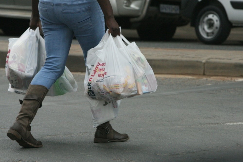 A shopper carries grocery bags Photo by Gallo Images