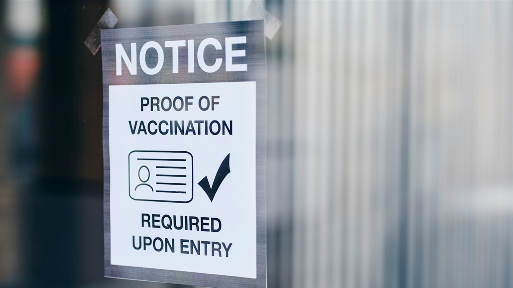 A business with a sign requiring proof of vaccinat