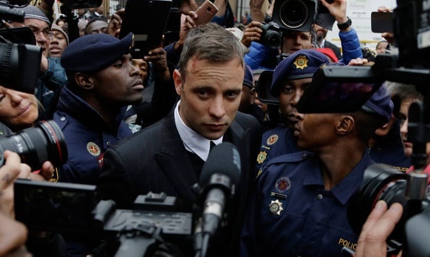 Oscar Pistorius is escorted by police officers as he leaves the High Court in Pretoria. (Themba Hadebe, AP)