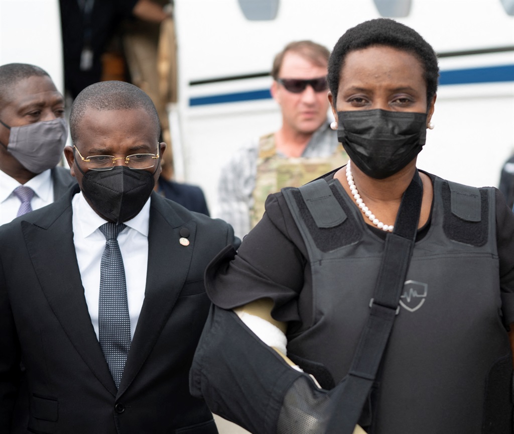 Foreign Minister Claude Joseph walks with Martine Moise, widow of Haiti's slain president Jovenel.