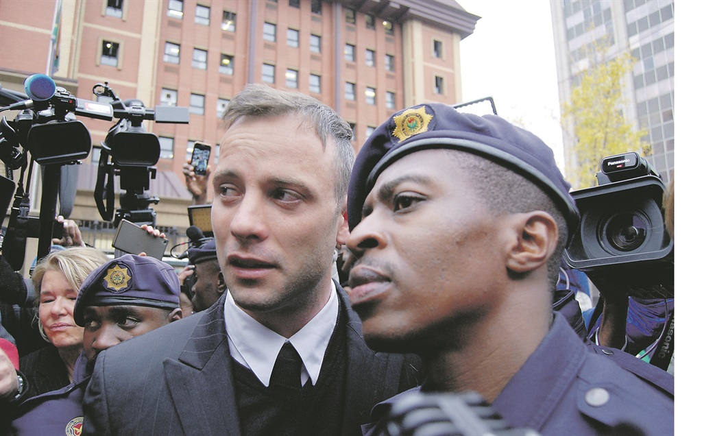 Pistorius and a police officer outside court. 