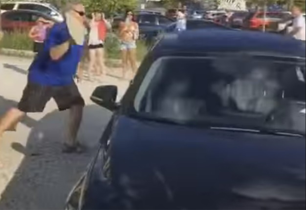 <B>FREE THE DOG!:</B> When this man saw a dog trapped inside a car, he went into absolute gorilla-mode to free the bewildered animal. <I>Image: YouTube</I>