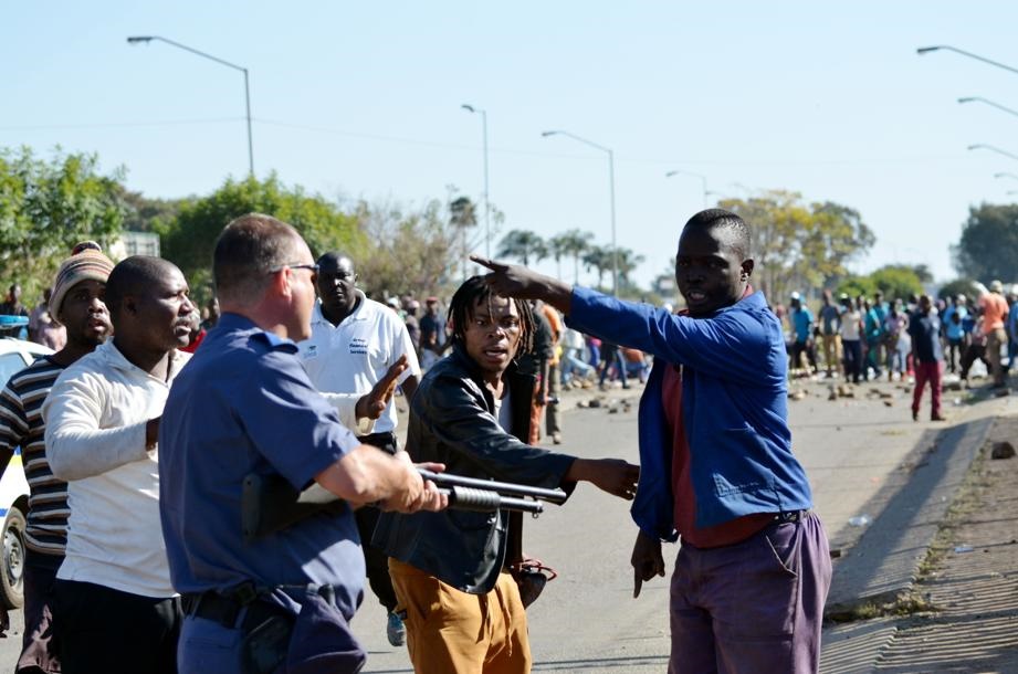 SHARP WORDS: Cops and community members in Hercules, Pretoria West, argue in the street. 
Photo by Christopher Moagi