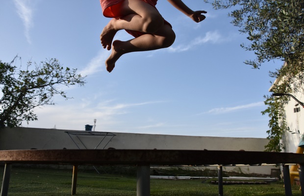 child jumping high on trampoline