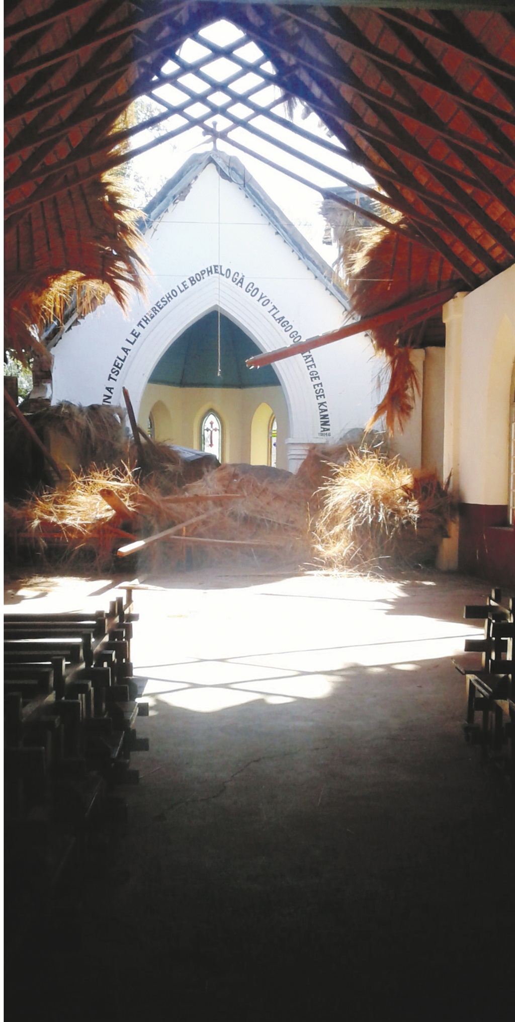 The thatch roof of the church (top) has fallen on to the altar and will take millions of rands to repair, while the valuable antique yellowwood benches stand open to the elements. Picture: Grethe Kemp 
