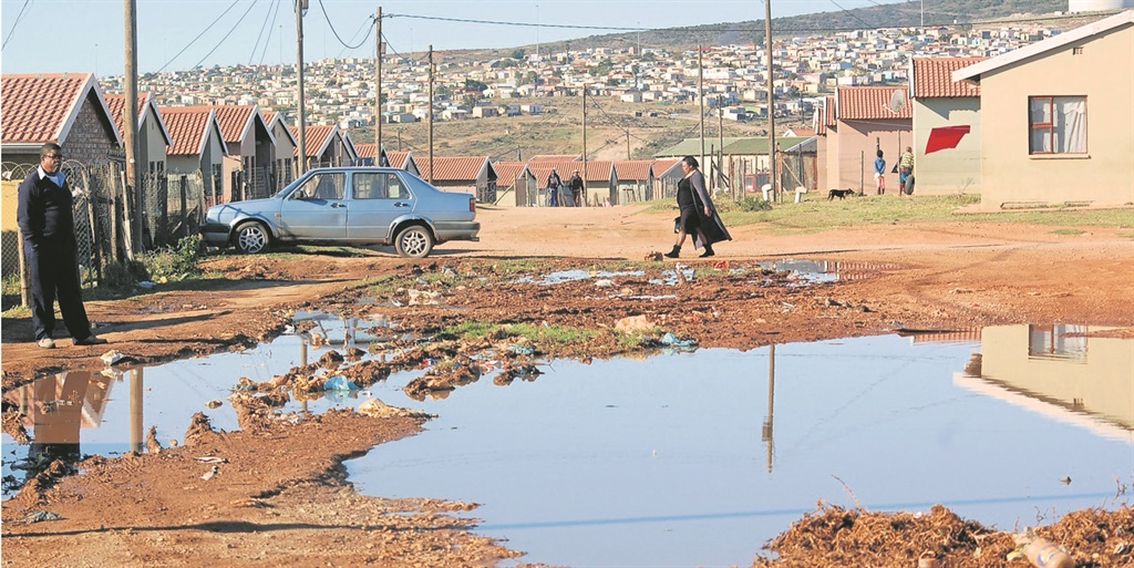 Thembekile Tini stares at the pool of sewage.       Photo by Thamsanqa Mbovane 