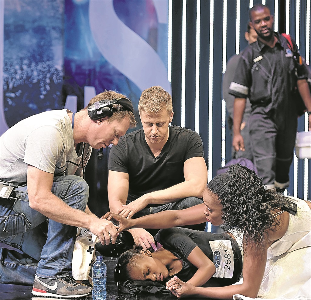 From left: A member of the M-Net crew and Idols SA judges Gareth Cliff and Unathi Msengana had to assist Nqobile Gumede after she collapsed during her audition.                 Photo by Gallo Images 