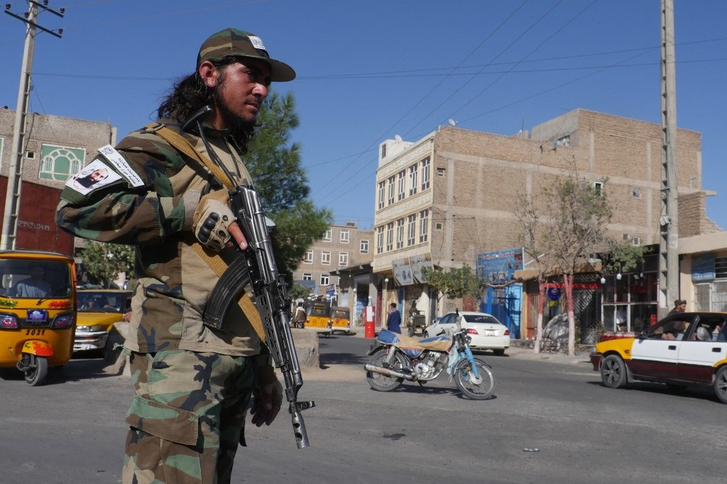 A Taliban fighter stands guard along a road after a blast during the Friday prayer in Gazargah mosque, in Herat on September 2, 2022.