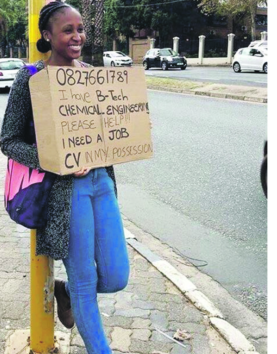 A graduate stands on a street corner begging for work  