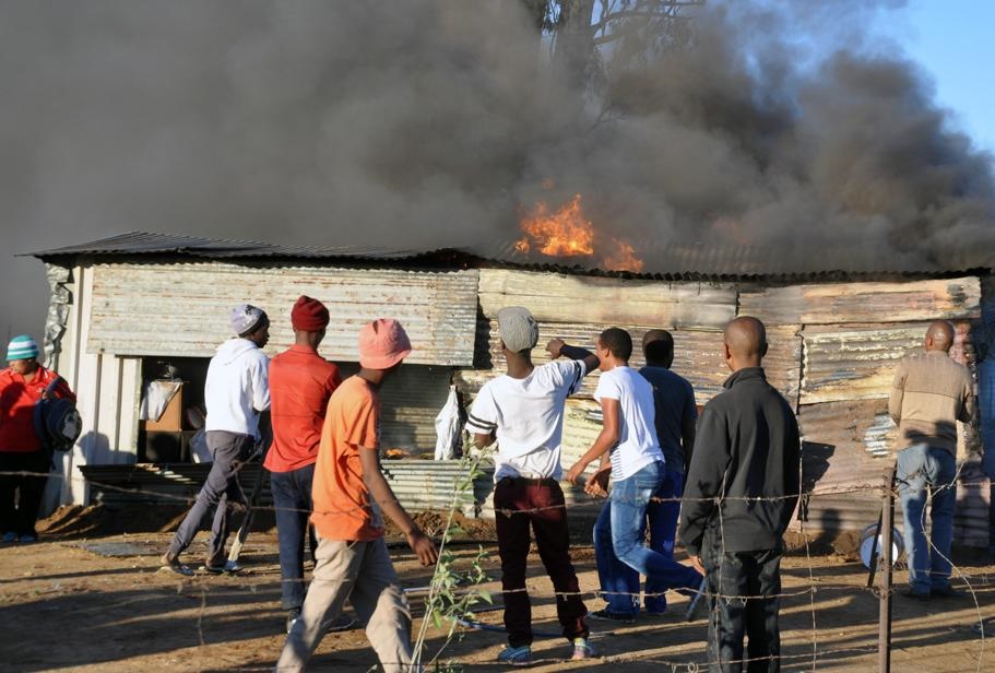 Residents try to fight the flames while waiting for fire-fighters to arrive on the scene. Photo by Kabelo Tlhabanelo
