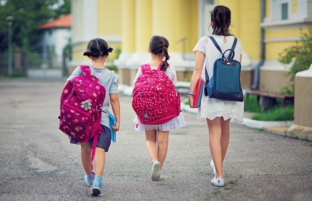 school girls carrying backpacks