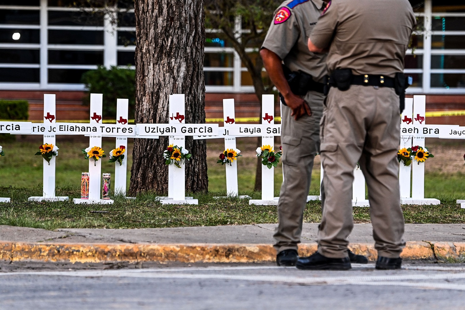 Police officers stand near a makeshift memorial for the shooting victims at Robb Elementary School in Uvalde, Texas, on May 26, 2022.