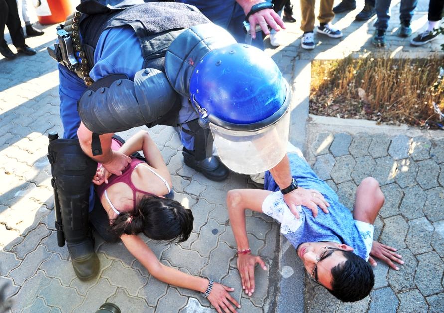 Two students were forced to the ground and detained by the police late afternoon on Wednesday, following the second day of clashes between students, private security and police at Wits University, Johannesburg. Photo: Leon Sadiki/City Press