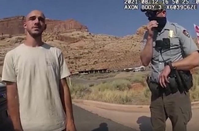This 12 August 2021, still image from a police bodycam released by the Moab City Police Department in Utah, shows Brian Laundrie (L) speaking with police.